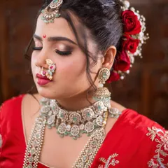 A beautiful profile shot showcasing the complete Maharashtrian bridal look, including the intricate hairstyle with fresh roses.