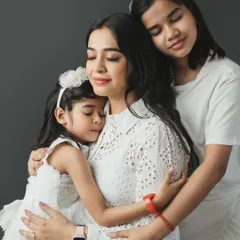A heartfelt studio portrait capturing the tender embrace between a mother and her two daughters. These are the quiet, emotional moments we strive to preserve forever in our mother-daughter photoshoots.