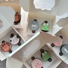 These animal face cupcakes are one of my most requested items for kids' parties. Here you can see a variety of cute fondant animals like a pig, frog, cat, and monkey, all packed and ready to go.
