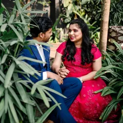 An intimate shot from the couple's pre-wedding photoshoot. Her makeup is soft and pretty, designed to look flawless up close and complement her vibrant pink dress.