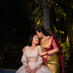 A mother's tender kiss on her daughter's forehead during her engagement celebration, a quiet moment of love and blessing.
