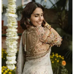 A candid shot of the bride, Ineka, looking over her shoulder with a natural smile. This portrait highlights the exquisite embroidery on her blouse and her effortless grace.