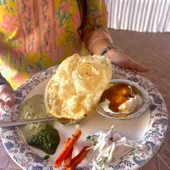 A plate filled with joy from my Republic Day brunch catering. This guest is enjoying a fluffy Bhatura with Chole, Dahi Vada, and a variety of chutneys. I create festive menus that bring people together over delicious food.