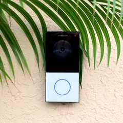 This Onetouch video door phone, set against a textured wall with natural elements, shows our commitment to discreet security. See and speak to visitors from your phone, ensuring you are always in control of who enters your home.