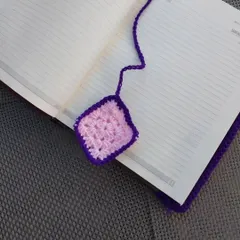 A handmade crochet granny square bookmark, perfect for keeping your place in your favorite book or diary.