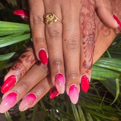 A full view of the vibrant pink and red ombre nails, showing how the colors blend together. The gold line art adds a touch of elegance.