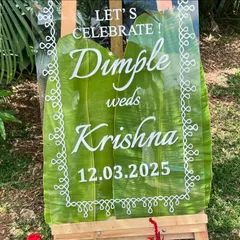 We designed this unique welcome sign for a wedding using a clear acrylic panel placed over a large banana leaf. The white script and traditional border design create a beautiful fusion of modern and authentic styles.