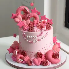 This dreamy pink cake was crafted for Vriha's sixth birthday. It's a perfect example of a loaded cake, adorned with edible beads, stars, donuts, and pretzels for a truly extravagant and fun look.