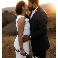 A golden hour kiss against a backdrop of sunlit hills. This classic romantic shot is filled with warmth, emotion, and beautiful light.