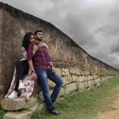 A quiet, intimate moment shared between a couple against the backdrop of Nandi Hills. The stormy sky adds a layer of cinematic drama to this pre-wedding portrait.