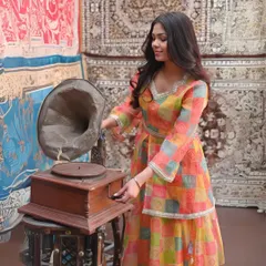 This vibrant, multi-colored checkered peplum kurti and skirt set showcases a playful and festive design. The layered look is stylish and can be tailored for different body shapes.