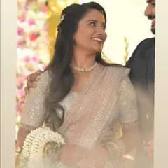 A candid moment of happiness. Her makeup is soft and glowing, paired with a half-up hairstyle that is perfect for her elegant, sequined reception saree.