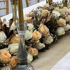 A closer look at the textured details of our tablescape, showing the intricate glass candle holders and the rich combination of peach and white roses. This level of detail creates a luxurious feel for your guests.