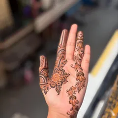 A simple and beautiful party henna design. The leafy vine gracefully flows down the side of the hand, complemented by detailed work on the fingers.