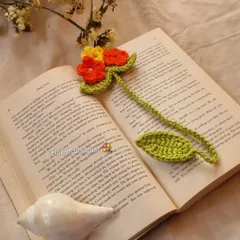 A closer look at the flower bouquet bookmark inside a book. The vibrant orange and yellow flowers bring a touch of nature to your reading time.