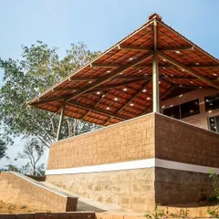 Here, the repeating pattern of the Mangalore tiles on the roof and the texture of the earth block wall create a pleasing visual rhythm. This demonstrates how simple, repeated elements can come together to form a cohesive and beautiful architectural design.