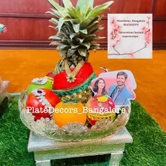 Another example of a personalized wedding fruit platter with a pineapple bride and a photo of the couple, surrounded by decorated fruits.