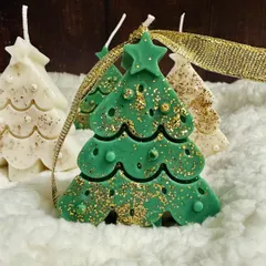 A green Christmas tree soy candle sparkling with gold glitter, a perfect addition to your holiday decor.