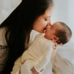 There is nothing more precious than a mother's love. This intimate moment was captured during an in-home newborn session, using soft natural light to highlight the tender bond between mother and her new baby.