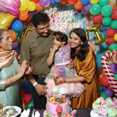 A sweet family moment during a Candyland-themed birthday party. The colorful backdrop and amazing cake make the photo even more special.