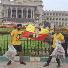 Two of our members holding up collected litter and a flag celebrating Karnataka. Plogging, or picking up trash while jogging, is a core part of our community service initiatives.