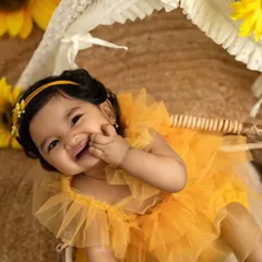 The sweetest giggle from a six-month-old baby girl during her sunflower-themed milestone session. Capturing these happy moments is my specialty.