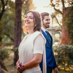 A candid shot where they are both laughing, facing away from each other but connected by their shared joy. The golden hour light adds a beautiful warmth to the scene.