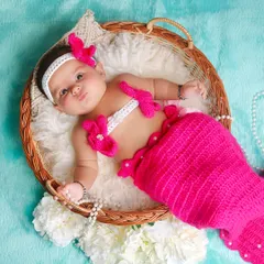 This little mermaid strikes a cute pose in her wicker basket. The turquoise background and pearl details complete the magical under-the-sea vibe.