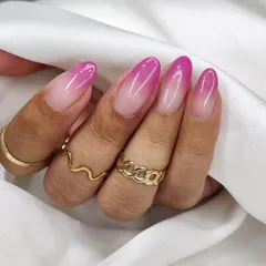 A beautifully blended pink ombré on almond-shaped nails. This gradient nail art transitions smoothly from a soft nude base to a vibrant magenta tip, creating a fresh and polished look.