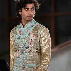 This is a truly special piece. A bandhgala jacket featuring a story-telling landscape embroidered with peacocks and palaces, paired with shimmering gold sequin sleeves for a modern twist.