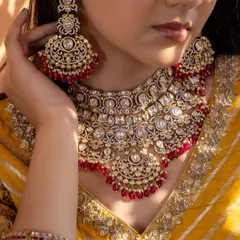 A close-up of our stunning red Kundan bridal choker set. The intricate arrangement of uncut stones and the rich red beadwork make this a classic choice for the traditional bride.