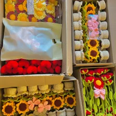 An overhead view of four open boxes, filled with a large wholesale order of potted sunflowers, hearts, and stems.