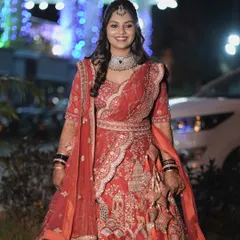 A full-length shot of the bride in her magnificent red reception lehenga. The makeup is bold and beautiful, perfect for a grand evening event.