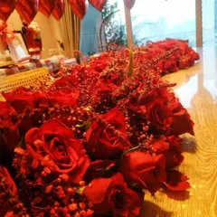 A detailed view of the magnificent floral table runner we created for a romantic occasion. It features a dense arrangement of deep red roses interspersed with delicate baby's breath, creating a rich texture that is both luxurious and passionate.