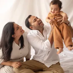 **Bright & Modern:** A joyful, candid family moment on a clean, all-white set. This style is fresh, airy, and perfect for capturing genuine laughter.