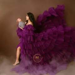 A creative and artistic portrait of a mother holding her newborn. The flowing purple gown and dreamy, cloud-like effect create a magical, ethereal scene.