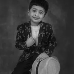 The same classic child portrait, presented in black and white. This version emphasizes the emotion in his eyes and the beautiful lighting, creating a dramatic and soulful image.