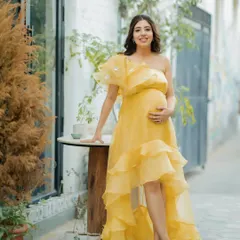 A full-length portrait of the mom-to-be at her "ray of sunshine" themed baby shower. She looks serene and beautiful.