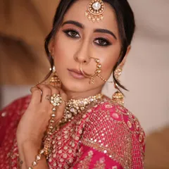 A detailed shot focusing on the traditional nath (nose ring) and haath phool (hand harness). These are essential pieces for a complete, classic bridal look.