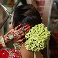 A classic bridal bun adorned with a fresh flower gajra. Learning how to incorporate floral elements is a key part of becoming a versatile bridal hairstylist.