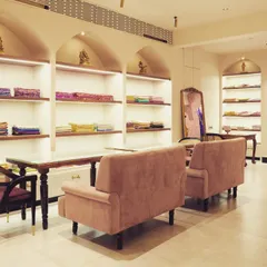 We designed comfortable seating areas for clients to relax and view the collections. The space features elegant arched niches with integrated lighting, perfectly illuminating the stacks of handloom fabrics.