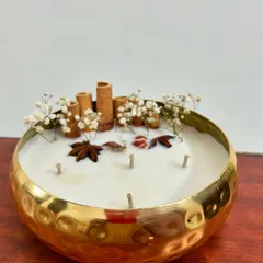This is one of my most premium offerings, a 6-inch golden metal urli candle. It’s filled with 100% soy wax and decorated with real cinnamon sticks and spices, making it a perfect centerpiece or a luxurious corporate gift for Diwali.