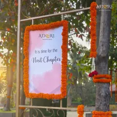 "It is time for the Next Chapter." A lovely welcome sign framed with fresh marigolds, setting a warm and optimistic tone for the wedding day.