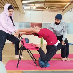 For many, deep backbends seem impossible due to stiffness or fear of injury. Here, I am assisting a student using a yoga chair for support, allowing them to safely open their spine and build confidence. My one-on-one therapeutic approach ensures that every pose is adapted to your body's specific needs.