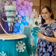 Here I am with the finished Frozen chandelier cake, right before the party started. Seeing the whole setup come together with the decor is one of the best parts of my job.