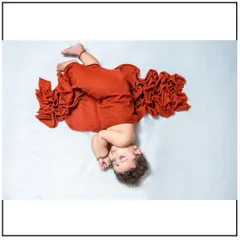 An artistic pose from a newborn photoshoot, showcasing how I can creatively style the swaddle wrap for a unique and beautiful image while keeping the baby secure.
