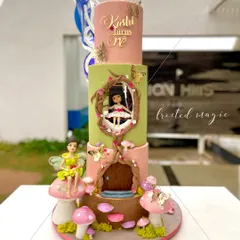 For a little princess's first birthday, I created this three-tiered enchanted fairy house cake. Every element, including the little girl on the swing and the fairy perched on a mushroom, is completely handmade from fondant to bring this magical world to life.