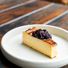 A perfect slice of my Basque Cheesecake, topped with a sweet berry compote. The cheesecake has a beautifully caramelized top and a creamy, melt-in-your-mouth interior. It's simple, elegant, and incredibly satisfying.
