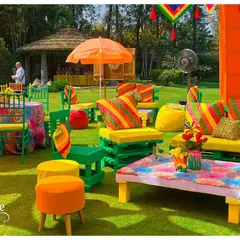 Bright and colorful seating arrangements for a Holi party, using painted pallets and vibrant cushions. This shows how I create functional and thematic lounge areas for large outdoor gatherings.