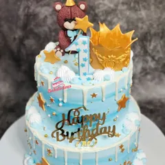 I loved creating this two-tier cake for a little one's first birthday. It features a cute, handcrafted teddy bear topper, a golden crown, and a gentle white chocolate drip over a dreamy blue frosting, making it perfect for a prince's celebration.